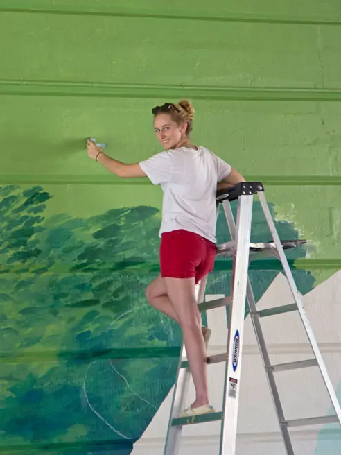 Sydney Welch '20 paints a public art mural.