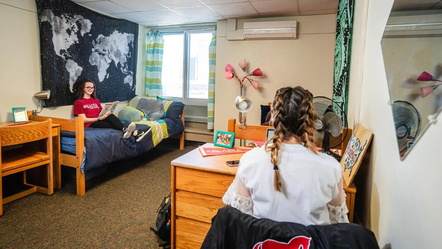 Two students reading in residence hall room.