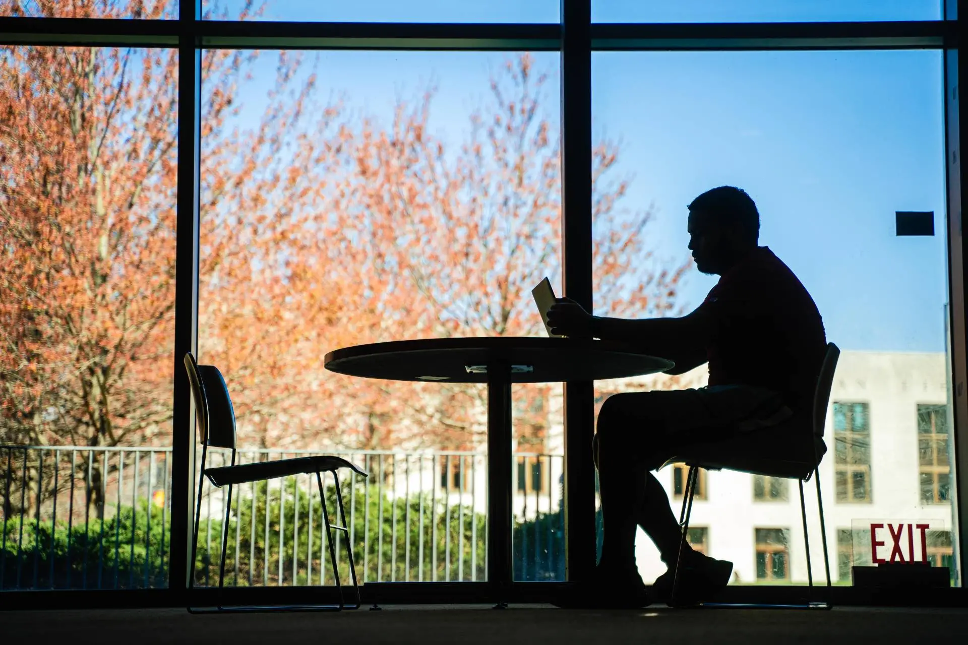 Silhouette of a student sitting at a table in Stein Fireplace Lounge.