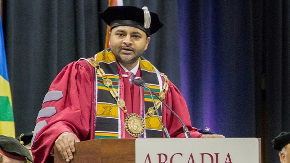 At a graduation ceremony Ajay Nair, Ph.D. President of Arcadia University speaks.
