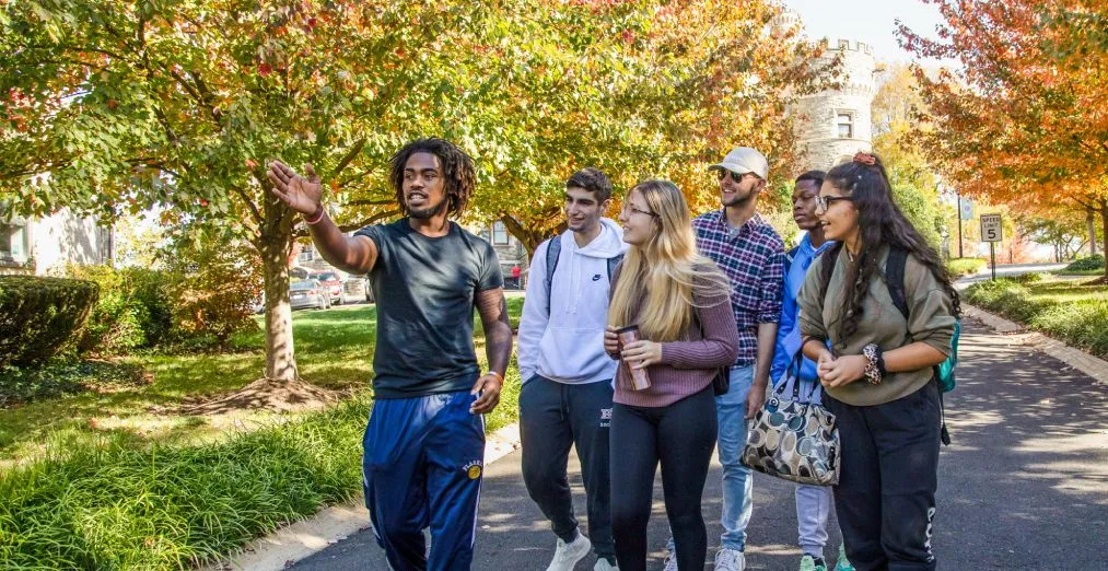 A group of six students tour the Arcadia University campus.