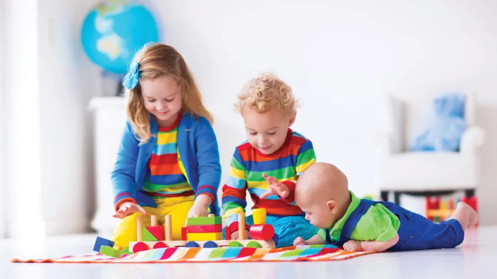 Young children play with colorful blocks.