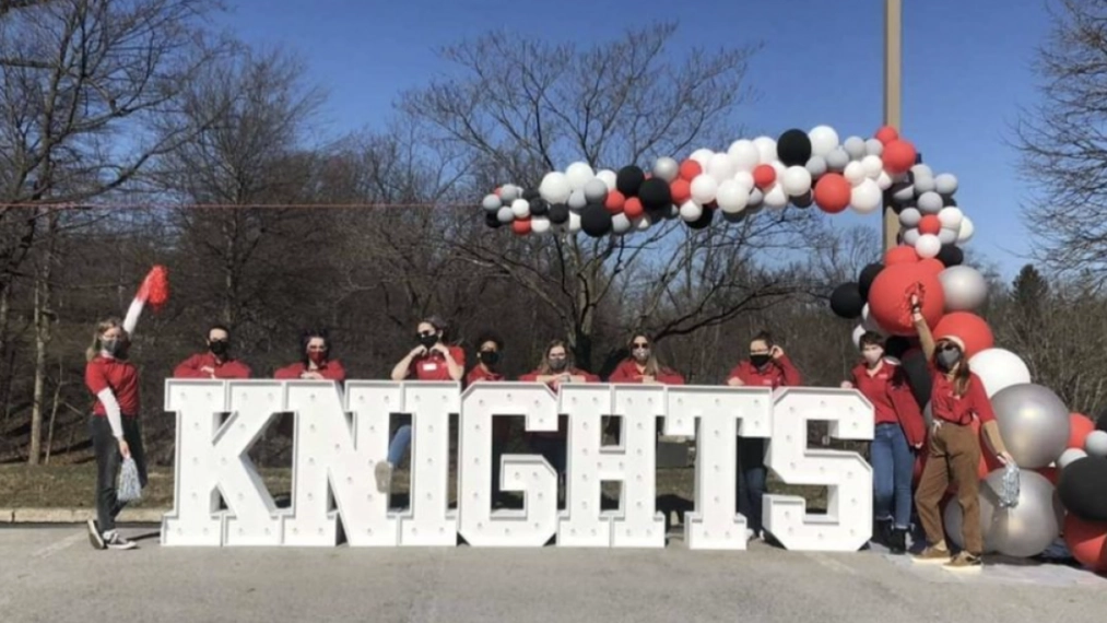 Students and alumni show their team spirit by an Arcadia Knights sign