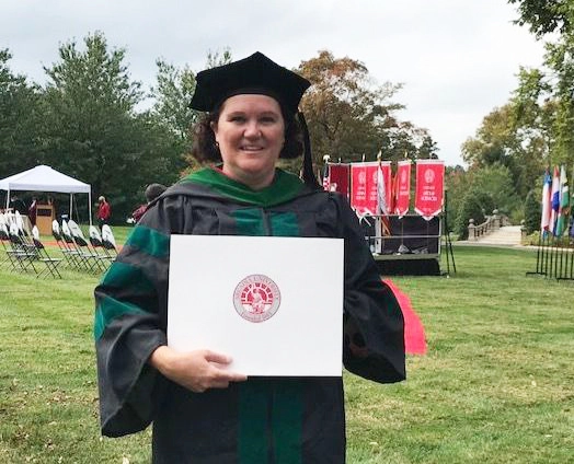 A physical therapy graduate shows her diploma during the ceremony on campus.