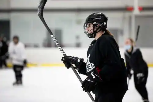 Student athletes playing ice hockey in the rink.