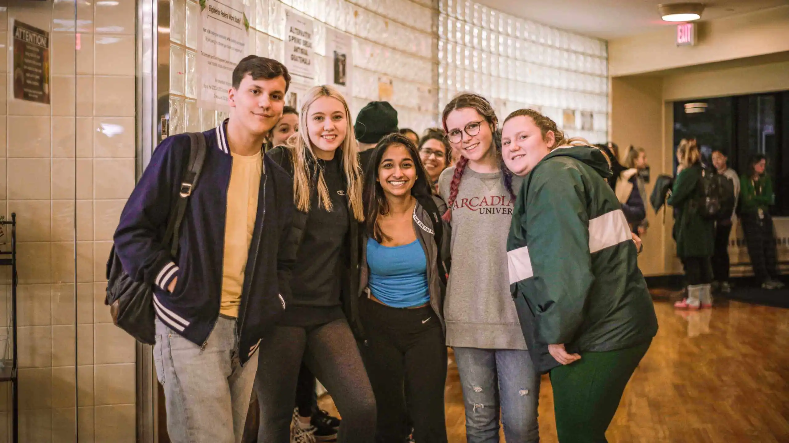 Five students standing together and smile at the camera for the Late Knight Breakfast