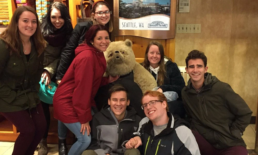 Group of honors students smiling at camera at a coffee shop.