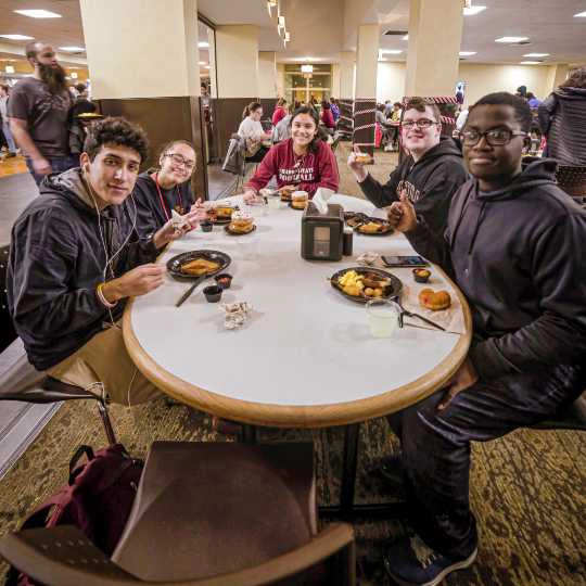 A group of students enjoy a meal together at Dining Services.