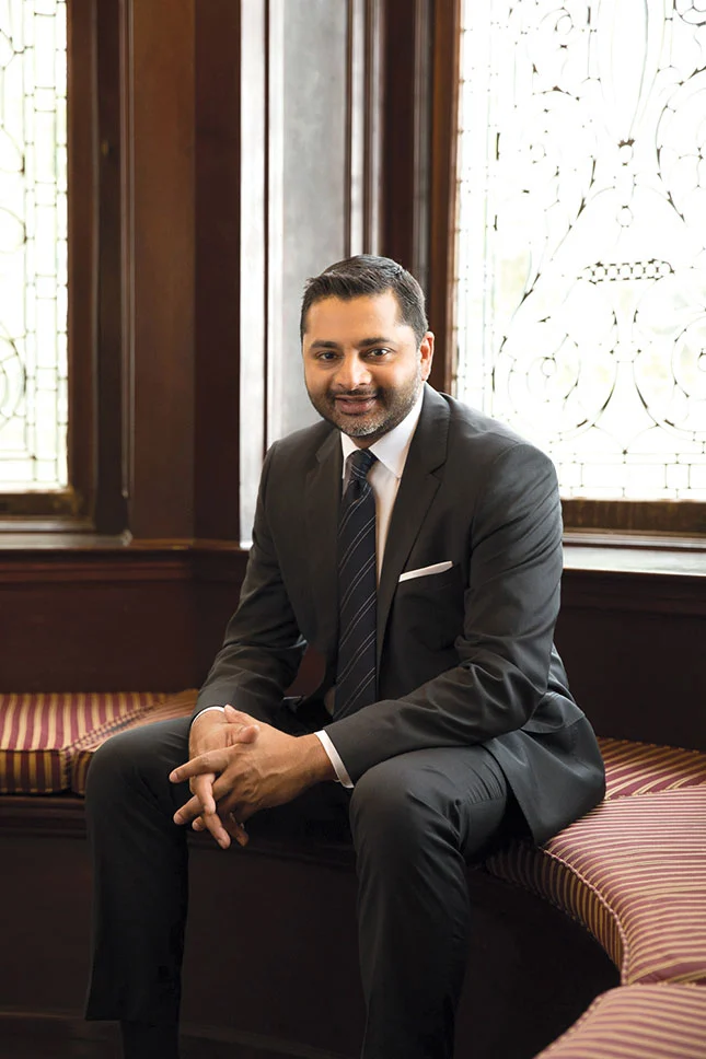Ajay Nair, Ph.D. President of Arcadia University sits in Grey Castle and smiles at the camera.