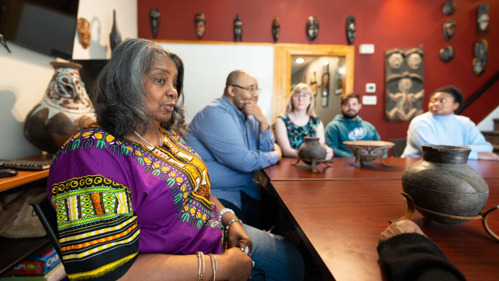 People gather around table for a discussion.