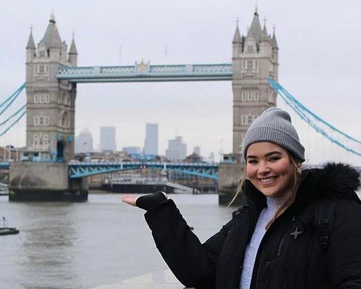 An Arcadia student smiling with London Bridge in the background.