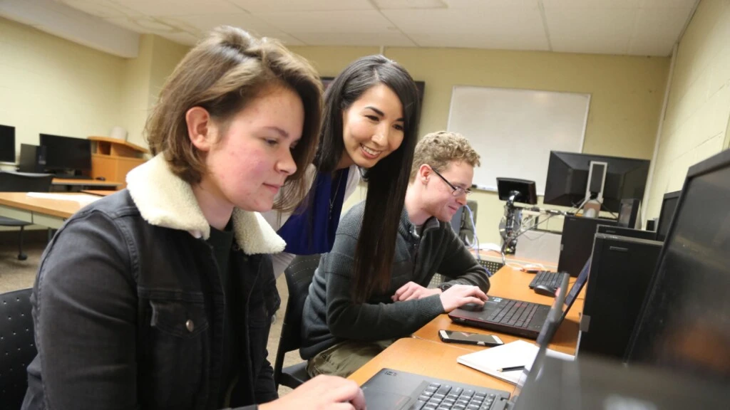 Dr. Kathy Macropol works with students in a computer lab.
