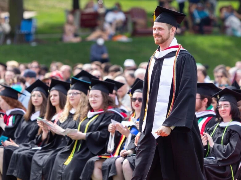 A student stands proudly during commencement.