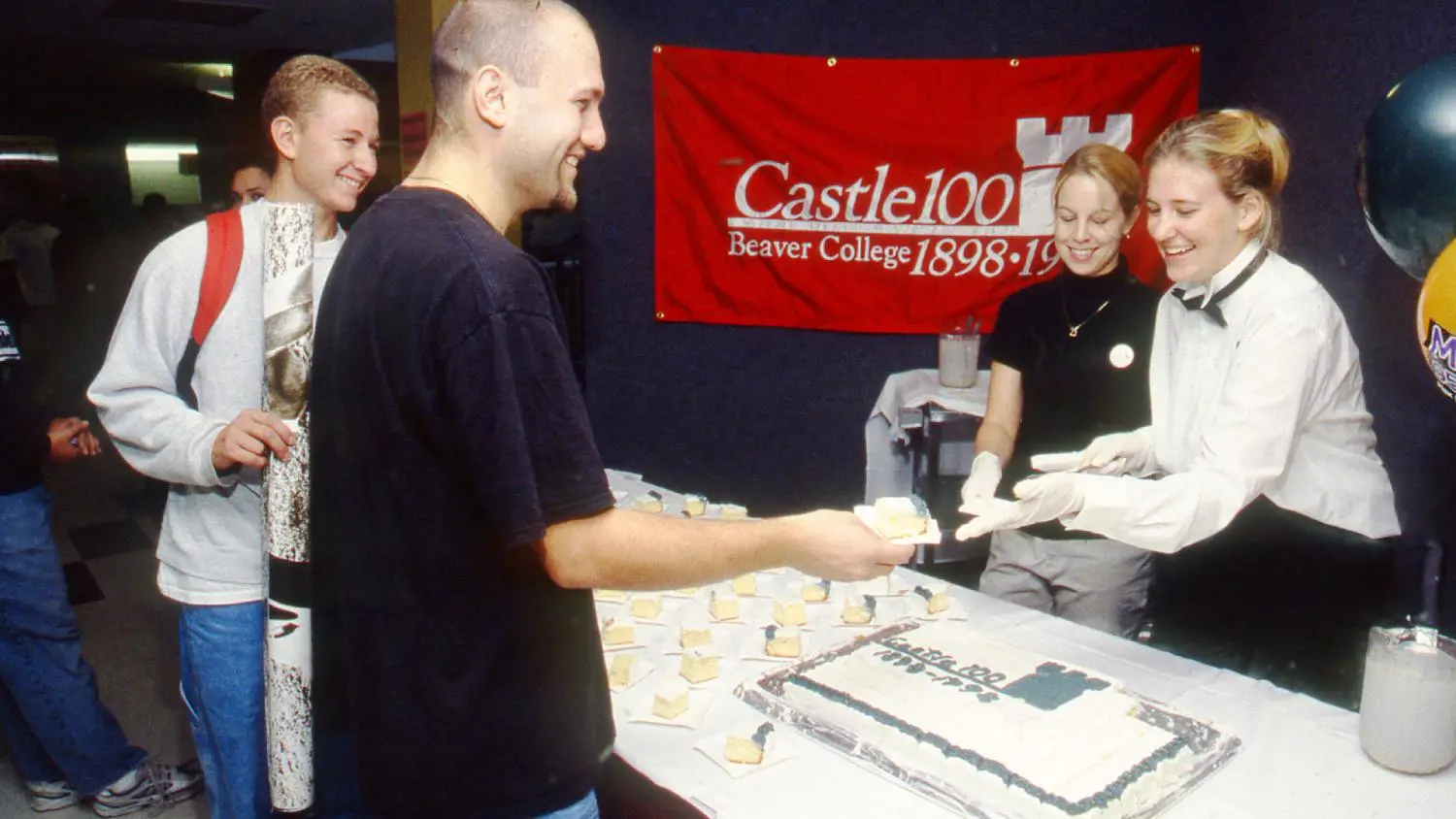 Beaver College students celebrate a milestone with cake.