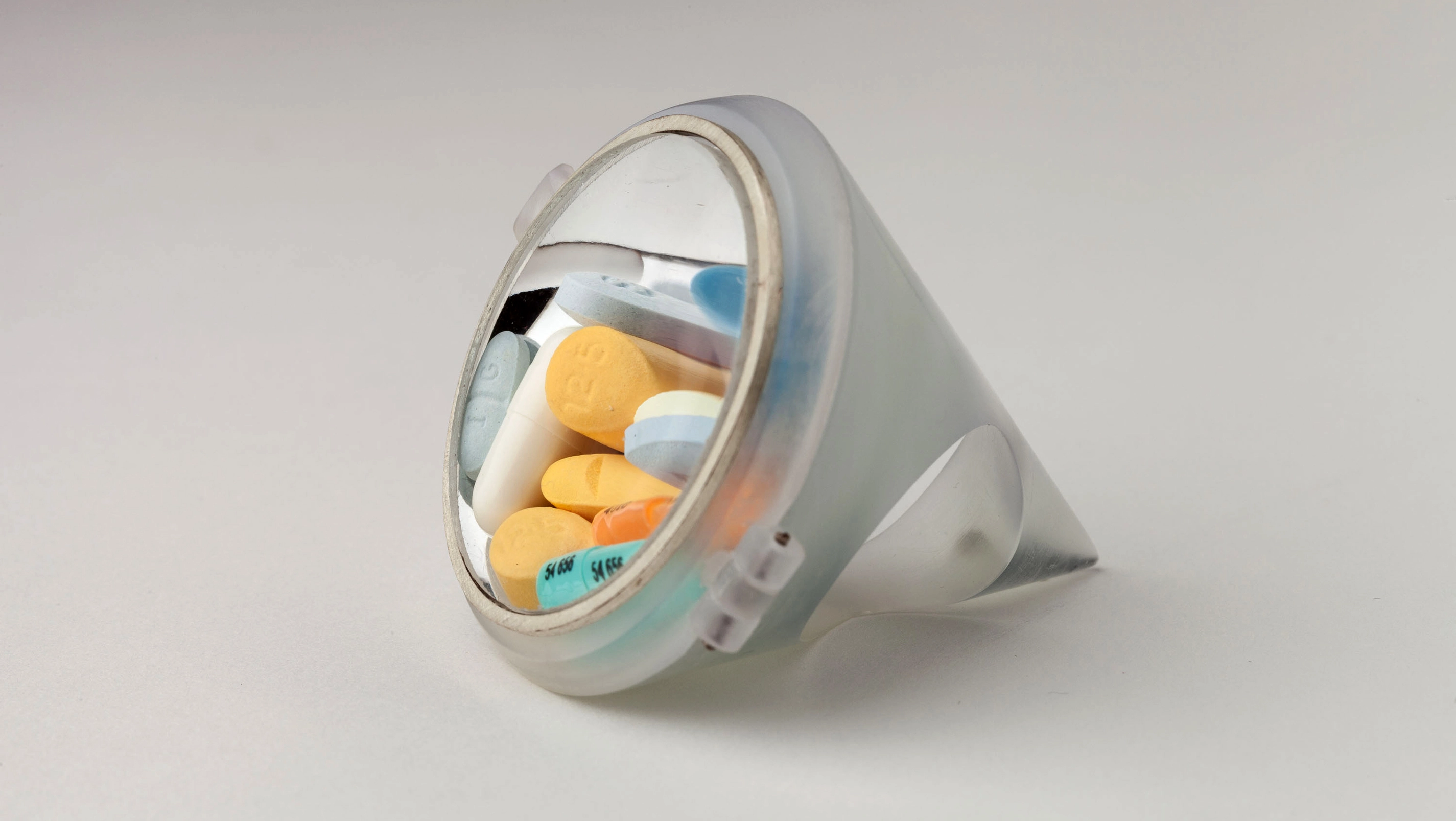 An art piece showing pills inside of a circular prism