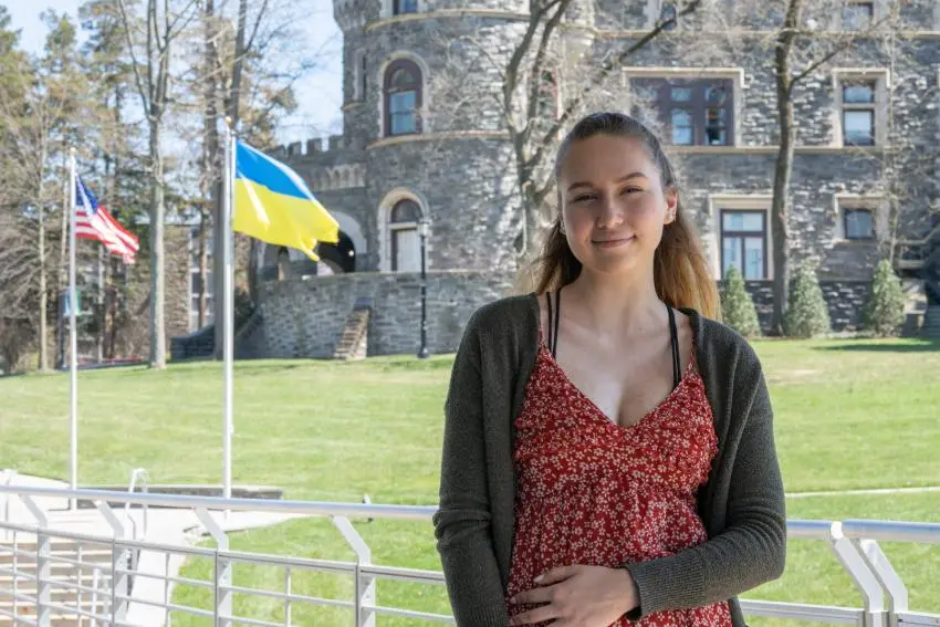 Victoria Fedorko outdoors with US and Ukraine flags behind her