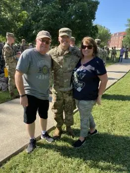 Dean with his father, Dean Cahill Sr., and mother, Maureen Cahill, posing outdoors at U.S. Army Cadet Command Advanced Camp graduation in Fort Knox, Kentucky.