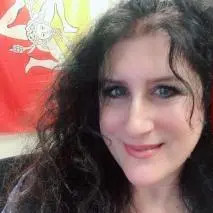 Dr. Michelle A. Reale smiles in front of a orange-yellow fabric backdrop