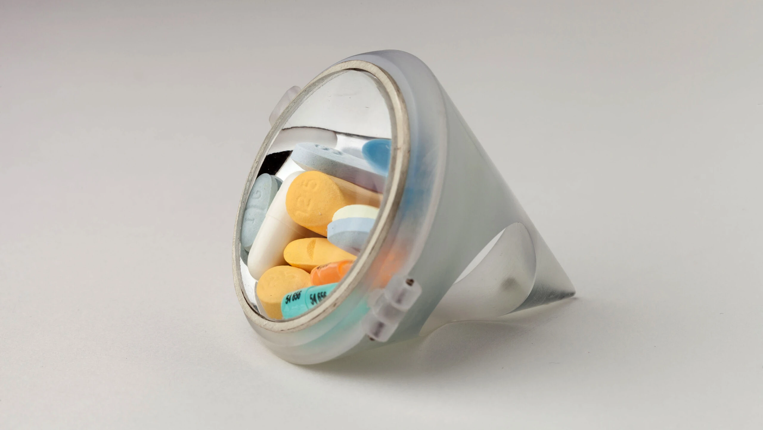 An art piece showing pills inside of a circular prism