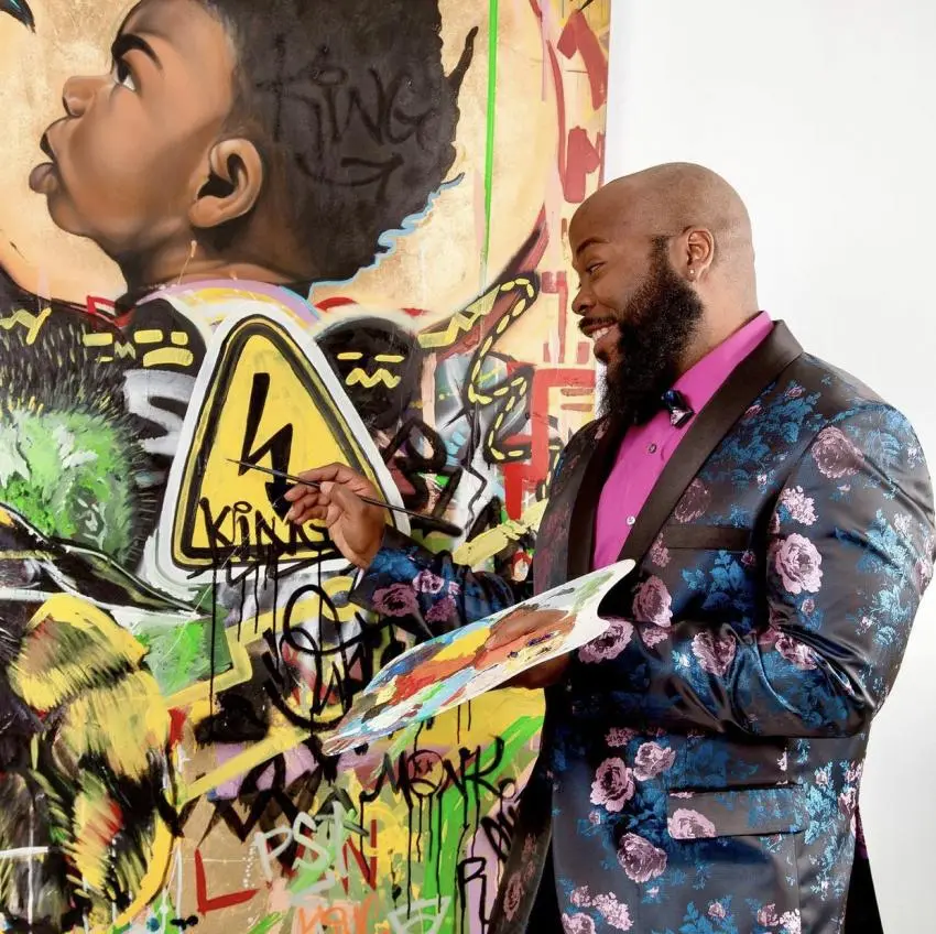 Visual artist Amir Campbell painting a mural