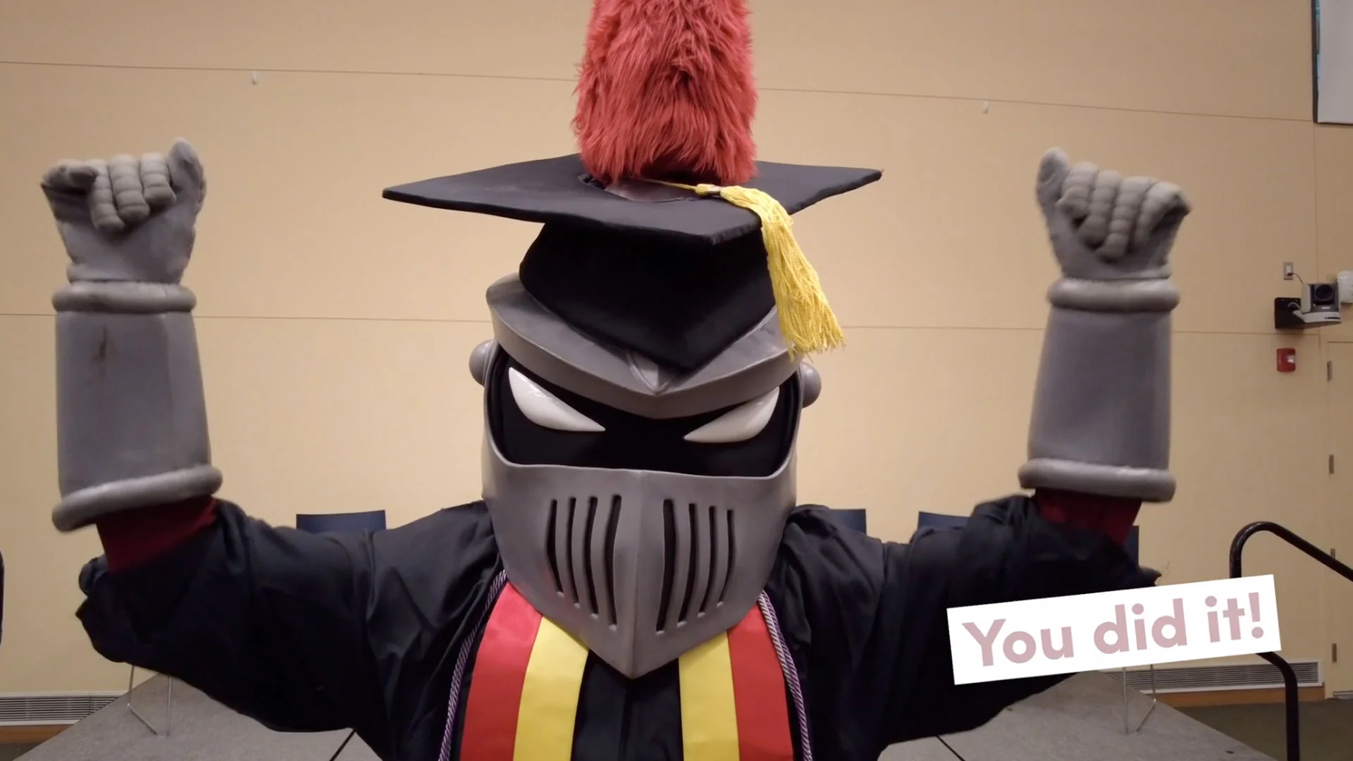The Knight mascot in a cap and gown