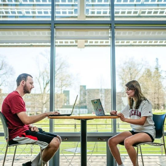 Students work on laptops in the Commons building