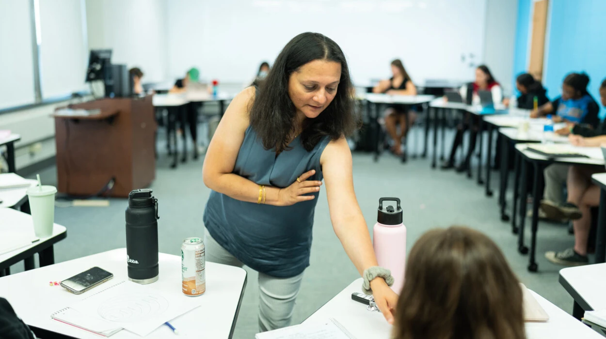 Prof. Bhukhanwala assists a student in the classroom.