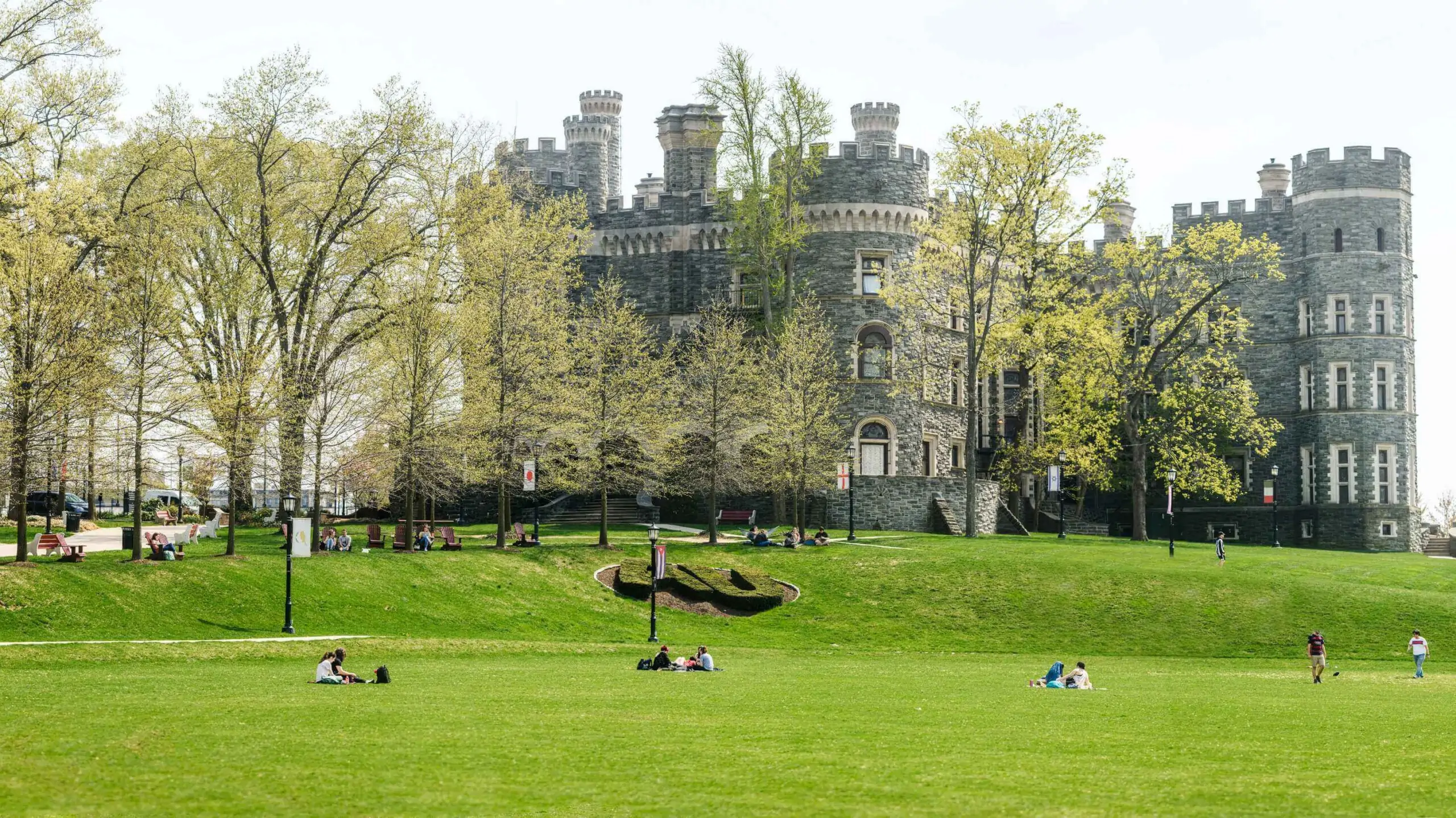 Students socialize across Haber Green in front of Grey Castle