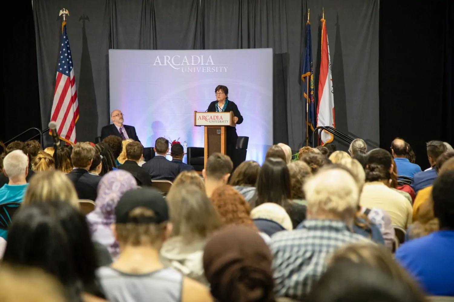 Sister Helen speaking at a podium about the common reads book