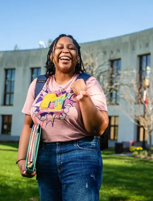 Student Daija Patton grins at the camera outside of a campus building
