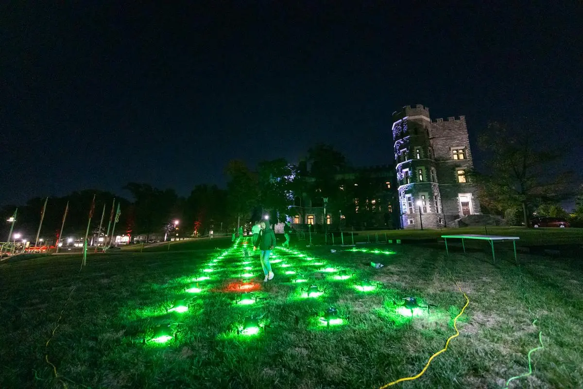 The drones for the drone show are lit up green on the ground before takeoff