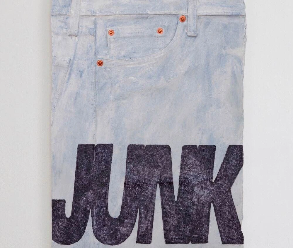 a plaster sculpture resembling a folded part of jeans with the word 