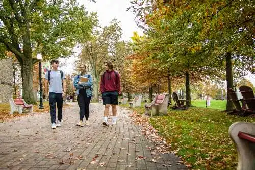 Students walk along paver sidewalk on campus