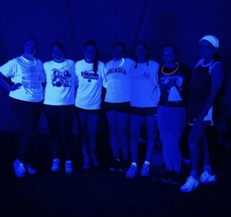 a black light volleyball team poses for a photo