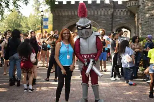 student and The Knight pose in front of the castle at the Welcome Parade