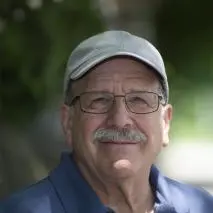 Louis M. Friedler, Professor Emeritus, Computer Science and Mathematics wears a hat and smiles.