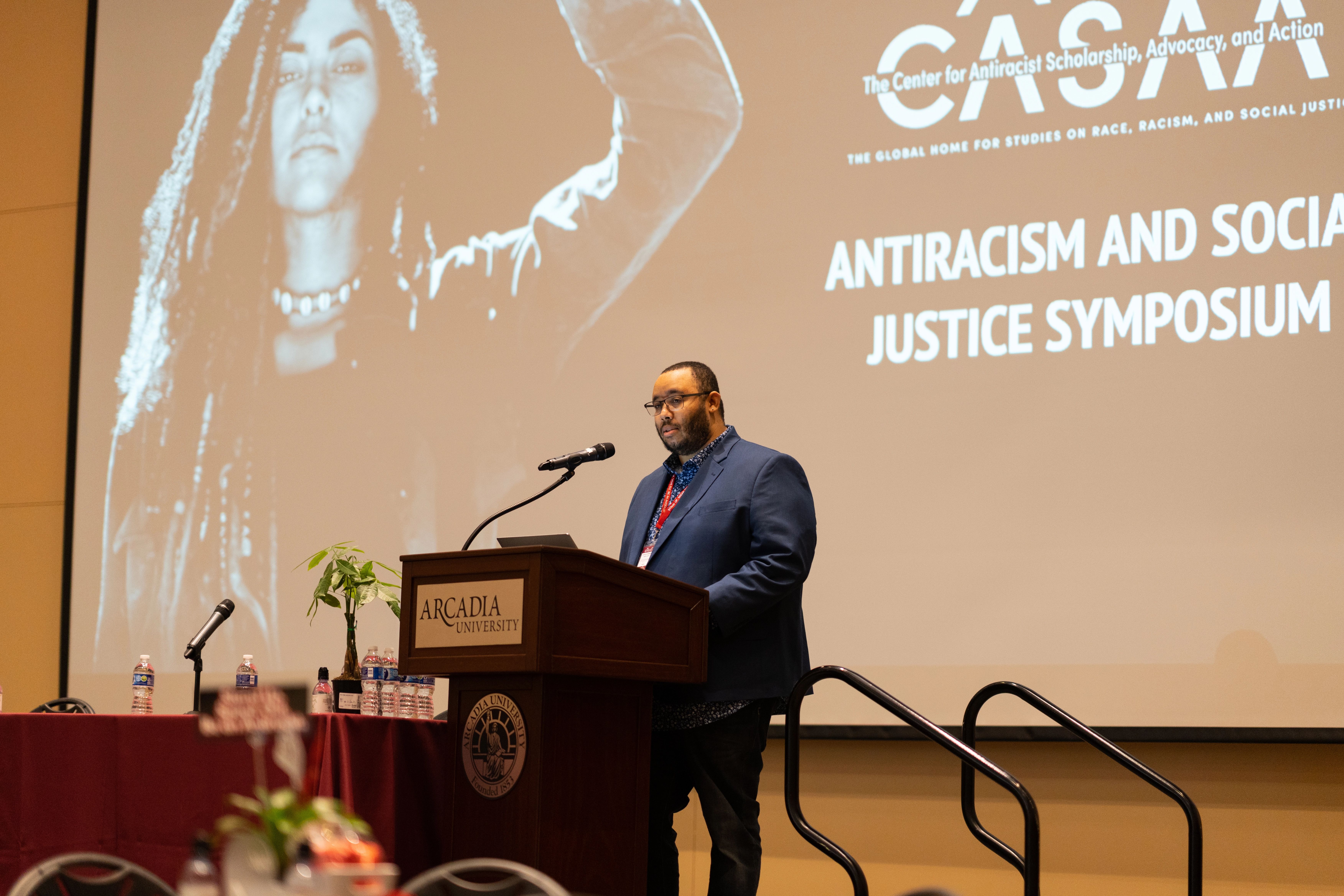 A speaker on podium at the CASAA Antiracism and Social Justice Symposium event