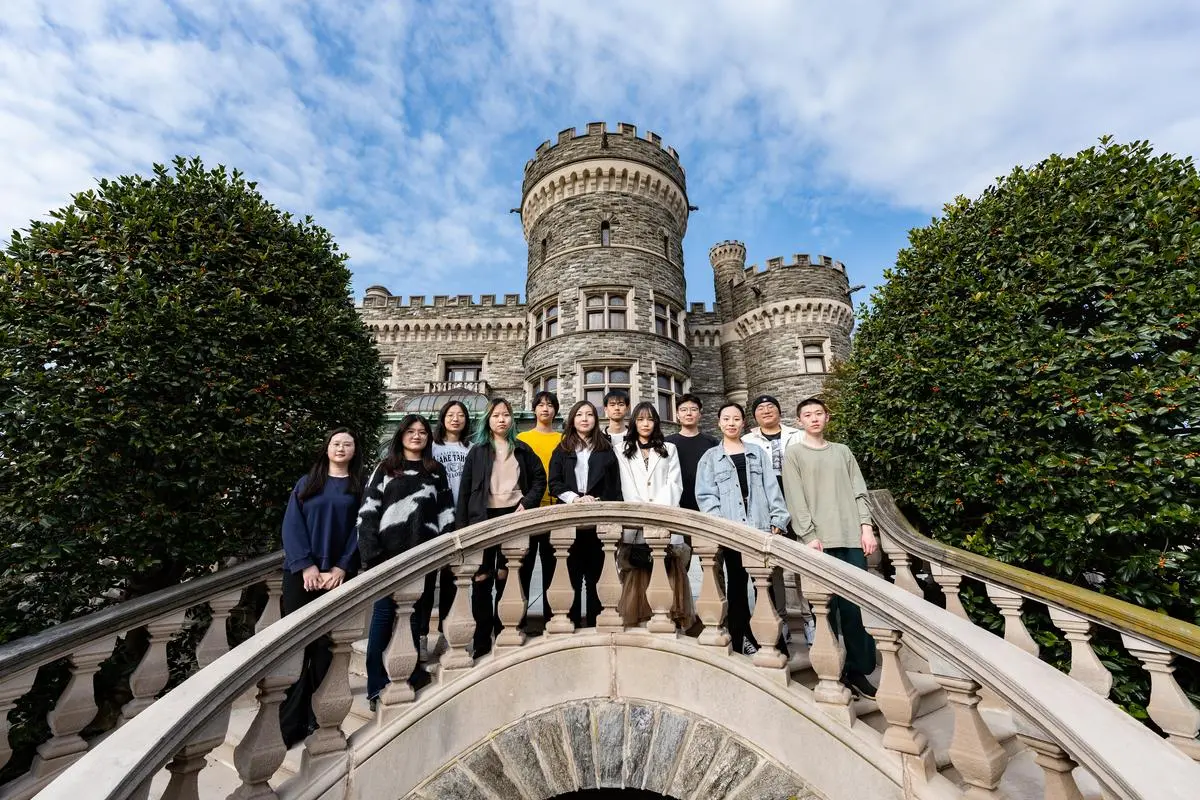 A portrait of 12 students outside the castle, Arcadia's 2023 graduates of the Jiangsu University program