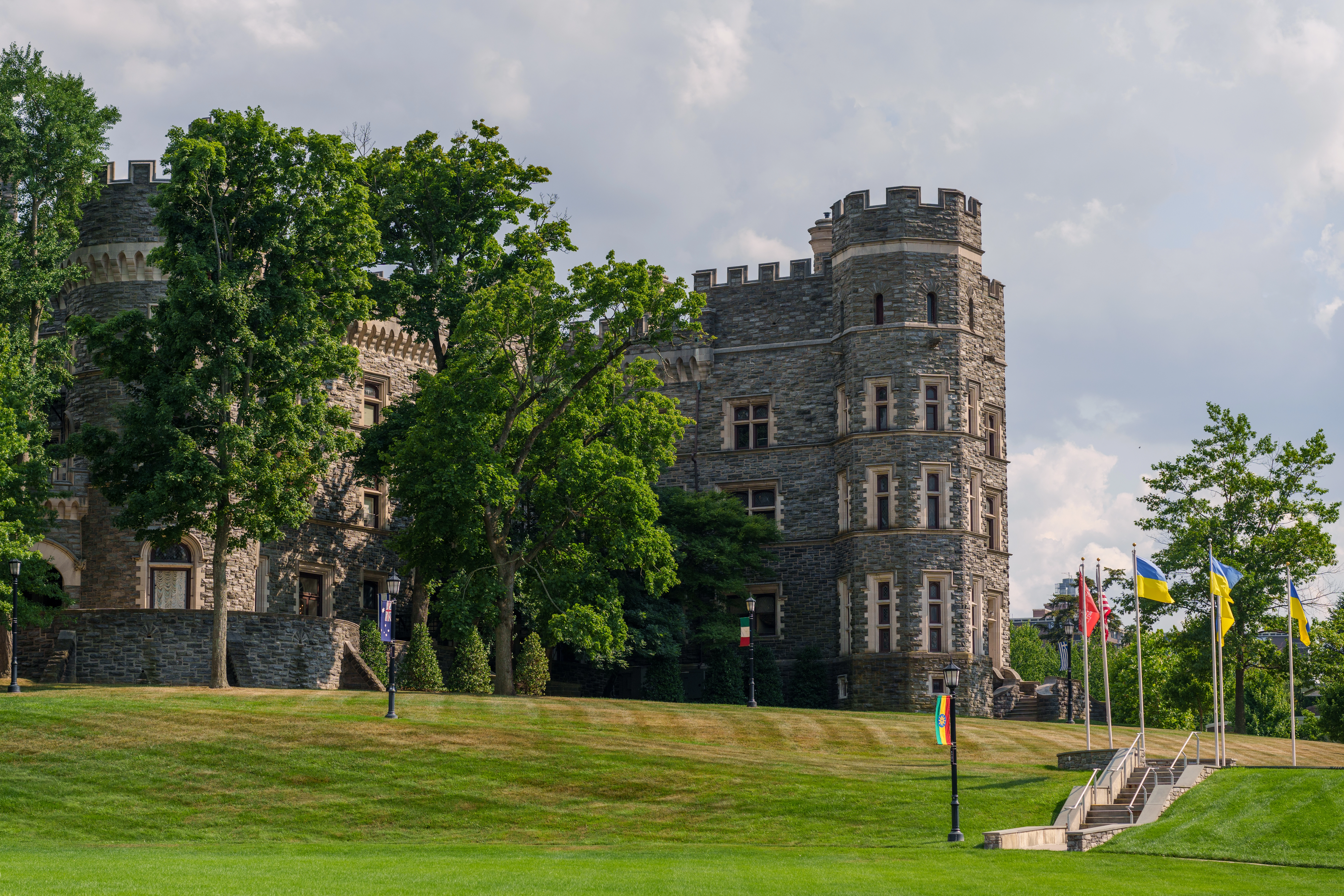 A sideview of Grey Towers with trees and flags in the surrounding