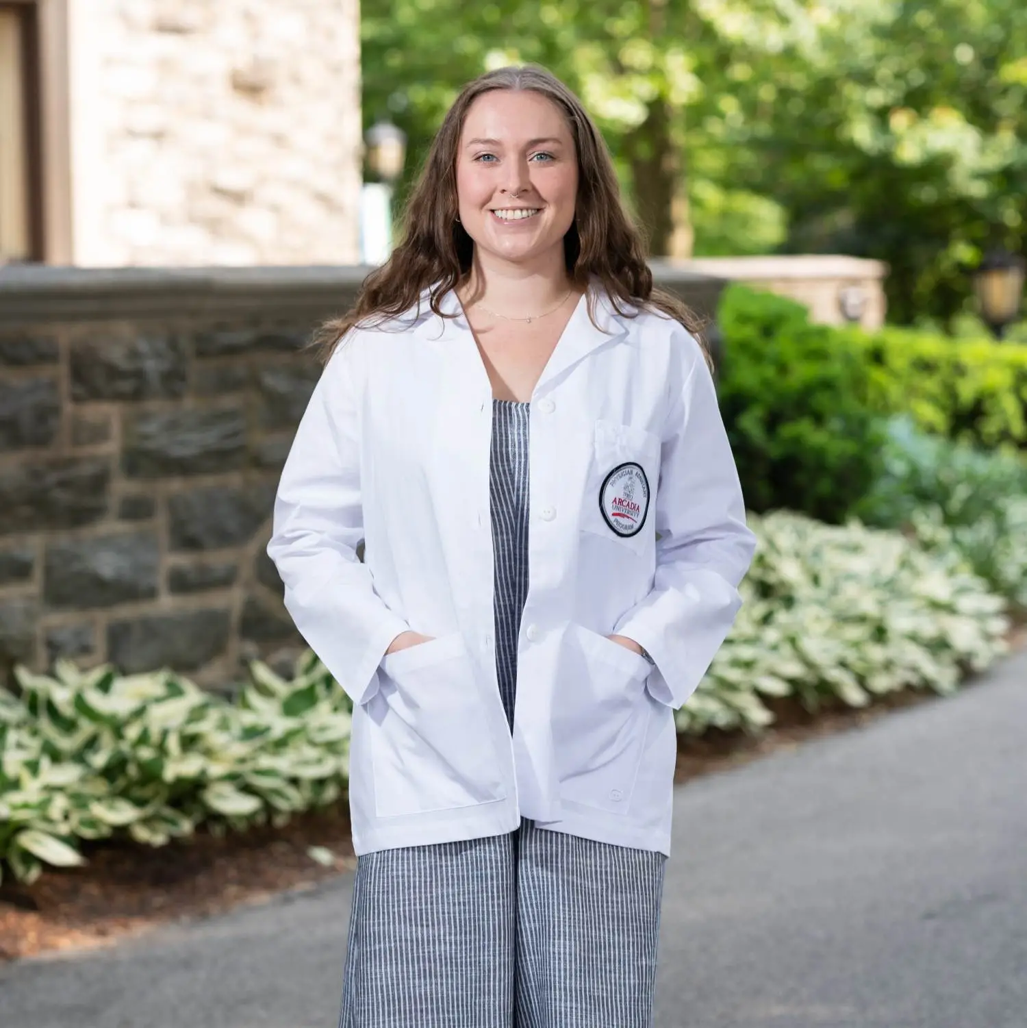 Martha Smee '25 MMS, MPH in a PA student white coat.