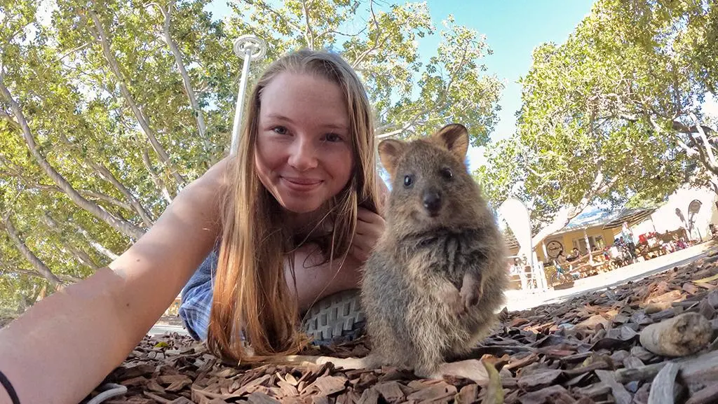 An Arcadia student poses with an Australian rottie rodent animal out in the field.