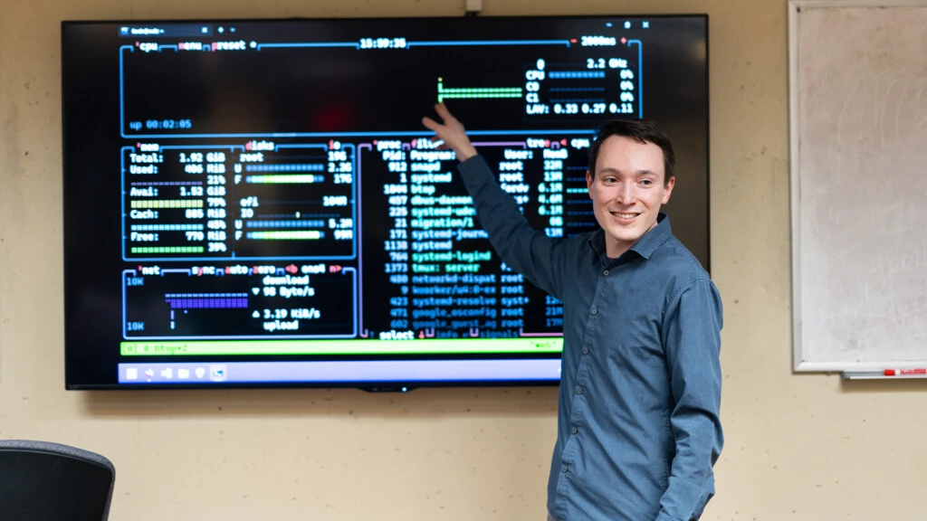 Vitaly Ford, Associate Professor teaches a computer science class to undergraduates using an electronic classroom board.
