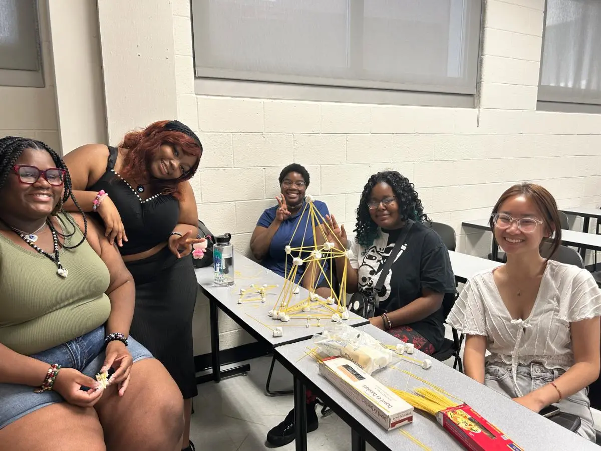 Students building a structure out of pasta and marshmallows.