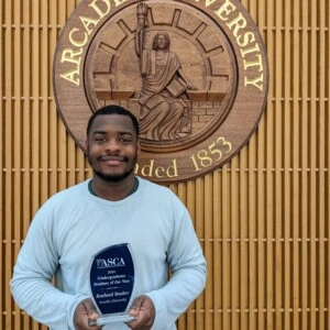 Rasheed Booker standing with his ASCA award.