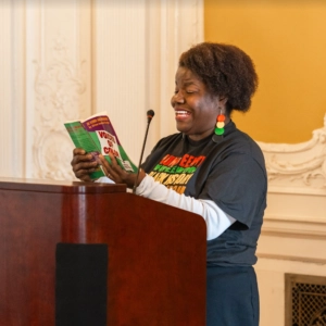 A speaker reading a novel for Black History Month.