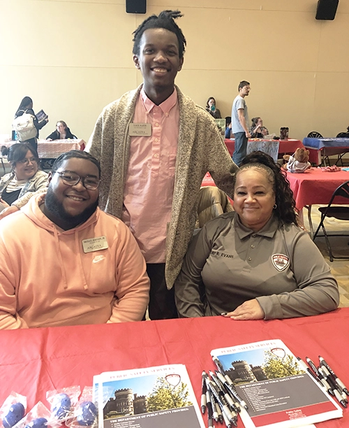 Public Safety Director Ruth Evans meets with two students at an event.