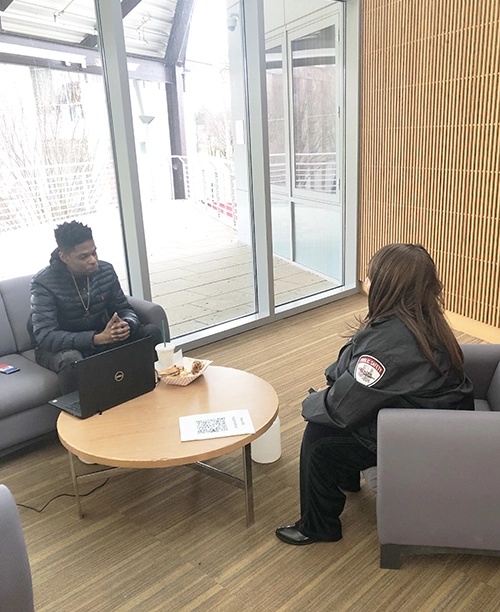 Public Safety Director Ruth Evans meets with a student in a lounge on campus.