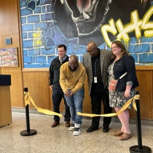 Amir Campbell cutting the ribbon to his mural.