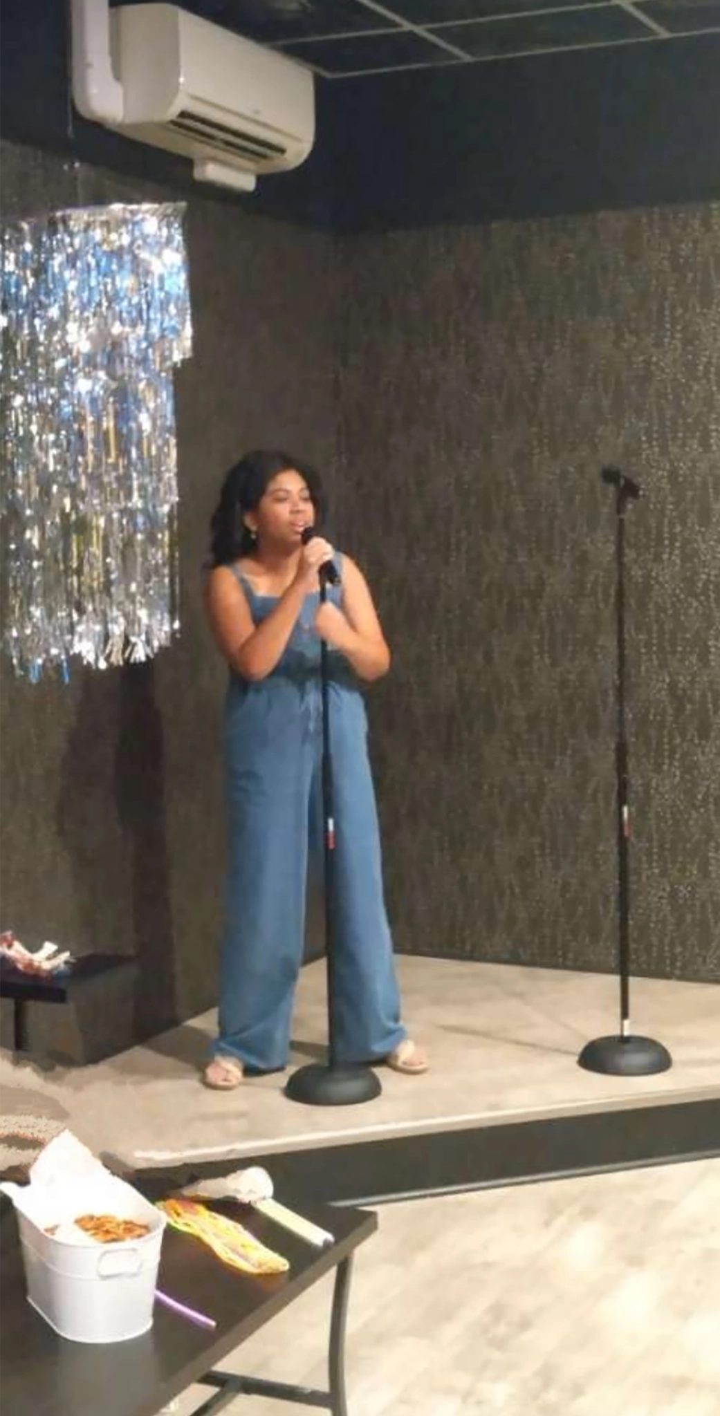 Zoe McNair standing on stage singing into a microphone.