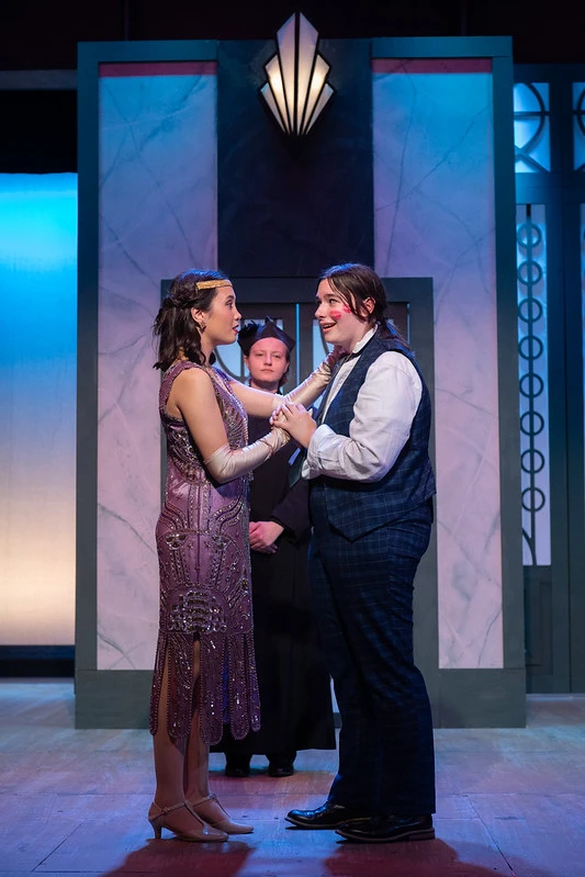 Three actors on stage for a play, where two are dancing.